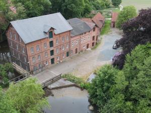 an aerial view of a large brick building next to a river at Wassermühle Stemmen in Kirchlinteln