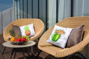 two wicker chairs with a bowl of fruit on a table at INX Design Hotel in Kraków