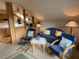 uma sala de estar com um sofá, cadeiras e uma mesa em Appartement Schwalbennest em Goslar