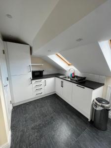 a kitchen with white cabinets and a black counter top at Cozy Penthouse suite happily sleeps up to five in Halifax