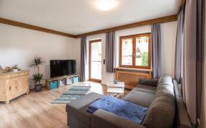 a living room with a couch and a tv at Neu! Sonnige Terrassen-Ferienwohnung in den Bergen in Bad Hindelang