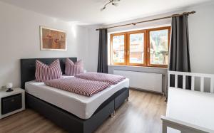 una camera da letto con un letto con cuscini rossi e bianchi di Neu! Sonnige Terrassen-Ferienwohnung in den Bergen a Bad Hindelang