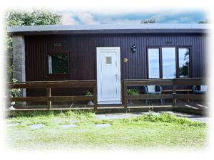uma pequena cabana com um alpendre e uma porta branca em Bay View Villas em Bucks Mills