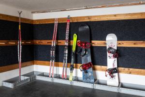 uma fila de snowboards e snowboards estão pendurados em uma parede em Chata u kostela em Kořenov