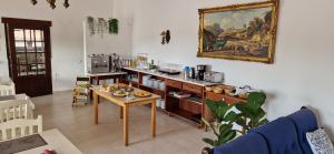 Casa Rosa Montes في لوز: غرفة معيشة مع طاولة و لوحة على الحائط