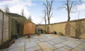 a courtyard with a brick wall and a fireplace at Malmesbury 3 Bedroom Town House in Malmesbury