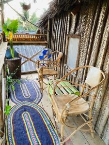 a pair of chairs and a rug on a porch at Kasuku Villa in Jambiani