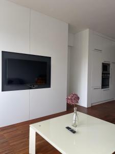 uma sala de estar branca com uma mesa branca e uma televisão em Apartmán Tera em Čeladná