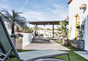 un patio avec une chaise et une table dans un bâtiment dans l'établissement Casa Rural Casa Levante, à Arcos de la Frontera