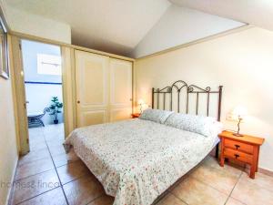 um quarto com uma cama e uma mesa com um candeeiro em Beautiful 3 Bed Townhouse in Islantilla Golf em Islantilla