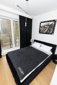 CedzynaにあるApartament Business & Living No 91 Nad Zalewem w Cedzynie, hala garażowaの黒いベッド1台(黒い毛布付)が備わるベッドルーム1室が備わります。