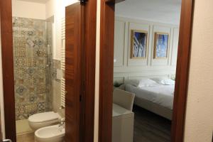 a bathroom with a bed and a toilet and a sink at pontevecchio rooms in Florence