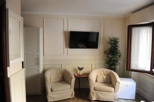 een woonkamer met 2 stoelen en een televisie bij pontevecchio rooms in Florence