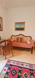 ein Sofa in einem Zimmer mit einem Tisch und einem Teppich in der Unterkunft Brač, Supetar, ART HOUSE, Dreamy Dalmatian vacation home, 80m from sea in Supetar