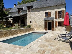 dom z basenem przed budynkiem w obiekcie Charme & piscine chauffée Périgord Noir w mieście Coly