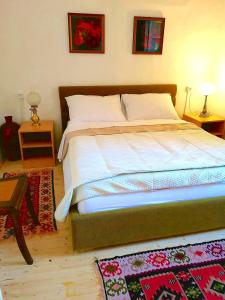 ein Schlafzimmer mit einem großen Bett mit zwei Lampen und einem Teppich in der Unterkunft Brač, Supetar, ART HOUSE, Dreamy Dalmatian vacation home, 80m from sea in Supetar