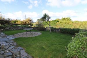 a garden with a picnic table in the grass at WALK TO THE BEACH, spacious cottage with sea views in Saint Merryn