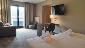 穆巴赫索蒙斯特Hotel Restaurant Perle Des Vosges的带床和书桌的酒店房间