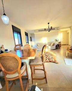 ein Wohnzimmer mit einem Holztisch und Stühlen in der Unterkunft Luxury duplex Port of Jaffa in Tel Aviv