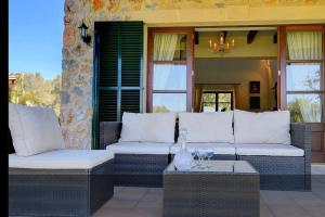 patio con 2 divani e tavolo con bicchieri da vino di Ecovilla Jeaninne by villasmediterranean a Inca