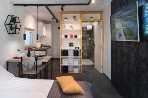 a room with a bed and a desk and a kitchen at HIŠA KAPIŠ with HOT TUBE in Koper
