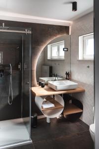 een badkamer met een wastafel en een douche bij HIŠA KAPIŠ with HOT TUBE in Koper