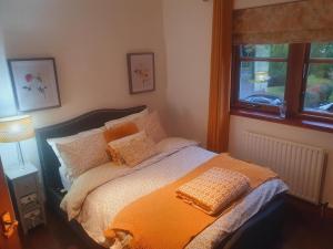 a bedroom with a bed with an orange blanket at Apartment at Drummond Crescent in Inverness