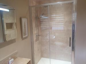 a shower with a glass door in a bathroom at Apartment at Drummond Crescent in Inverness