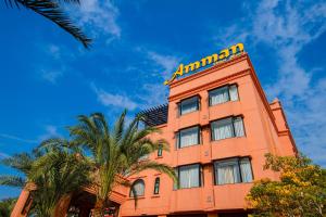 乌隆他尼Amman Unique Hotel的一座高大的橙色建筑,屋顶黄色