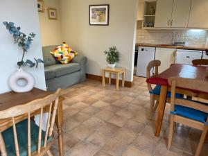 a kitchen and living room with a table and a couch at Rural Farm Cottage Easy Commute To Cambridge in Cambridge