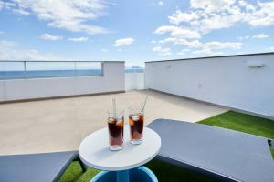 dos bebidas sentadas en una mesa en un balcón en Penthouse with stunning view and rooftop terrace, en Manilva