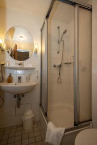 a bathroom with a shower and a sink and a tub at Hotel Schlangenbader Hof in Schlangenbad