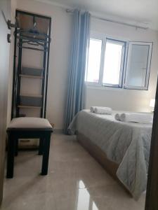 a bedroom with two beds and a chair and two windows at Sunrise Apartment 2 in Souda