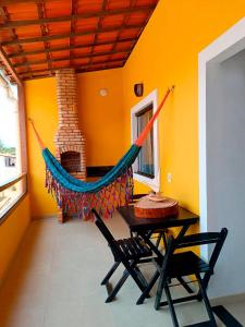 hamak w pokoju ze stołem i krzesłami w obiekcie Casa do Sol Flecheiras w mieście Trairi