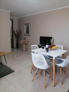 a dining room with a white table and chairs at Sunrise Apartment 2 in Souda