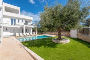 drzewo w ogrodzie domu z basenem w obiekcie STUNNING VILLA MARIANELLA GRIS, POOL, BBQ, AC, FREE WIFI w mieście Cala d´Or