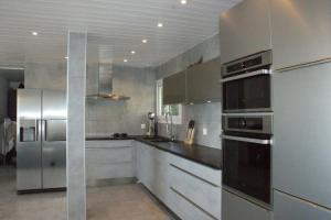 eine Küche mit Küchengeräten aus Edelstahl in der Unterkunft Villa Escondida 1 in Blonay