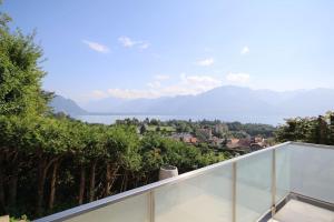 a balcony with a view of the water and trees at Villa Escondida 1 in Blonay