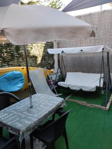 a table and a chair under an umbrella at Casetta di Myra in Bari