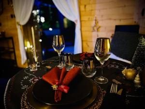 une table avec une plaque noire avec une serviette rouge et des verres à vin dans l'établissement Les Sources d'Hon - Gîte & Espace wellness, 