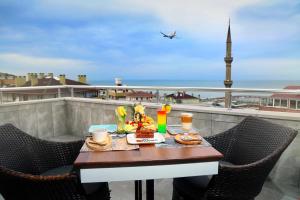 una mesa y sillas en un balcón con vistas al océano en Marvell City Otel, en Trabzon