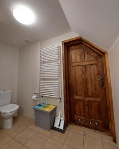 La salle de bains est pourvue de toilettes et d'une porte en bois. dans l'établissement Tulin, à Wetlina