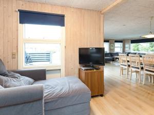 uma sala de estar com um sofá e uma televisão de ecrã plano em Holiday home Otterup XXXI em Otterup