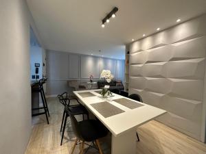 a kitchen and dining room with a white table and chairs at Chartres Charming Residence in Fortaleza
