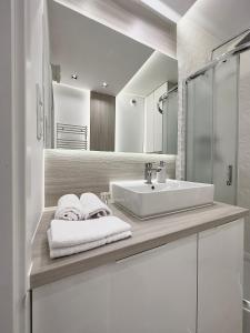 a white bathroom with a sink and a mirror at MIA Centrum Wrocław in Wrocław