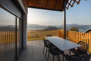 a patio with a table and chairs on a balcony at Villa Strtenica in the vineyard in Pristava pri Mestinju