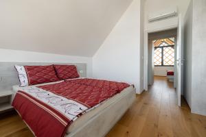 a bedroom with a bed with a red comforter at Villa Strtenica in the vineyard in Pristava pri Mestinju