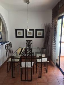 a dining room with a glass table and chairs at Mirador La Pita Azul in San José