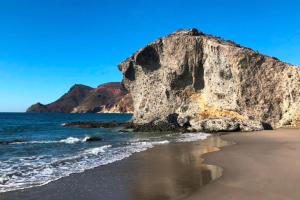 a beach with a large rock in the ocean at Mirador La Pita Azul in San José