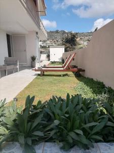 a patio with a bench and some plants at Sunrise Apartment 2 in Souda